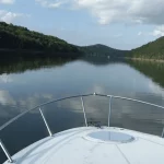 photo of a boat sailing on a river in the middle of a forest