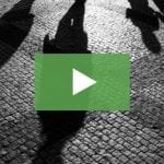 clickable video thumbnail depicting various human shadows on a cobbled street