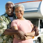 African american husband and his wife embracing in front of their RV