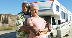 African american husband and his wife embracing in front of their RV